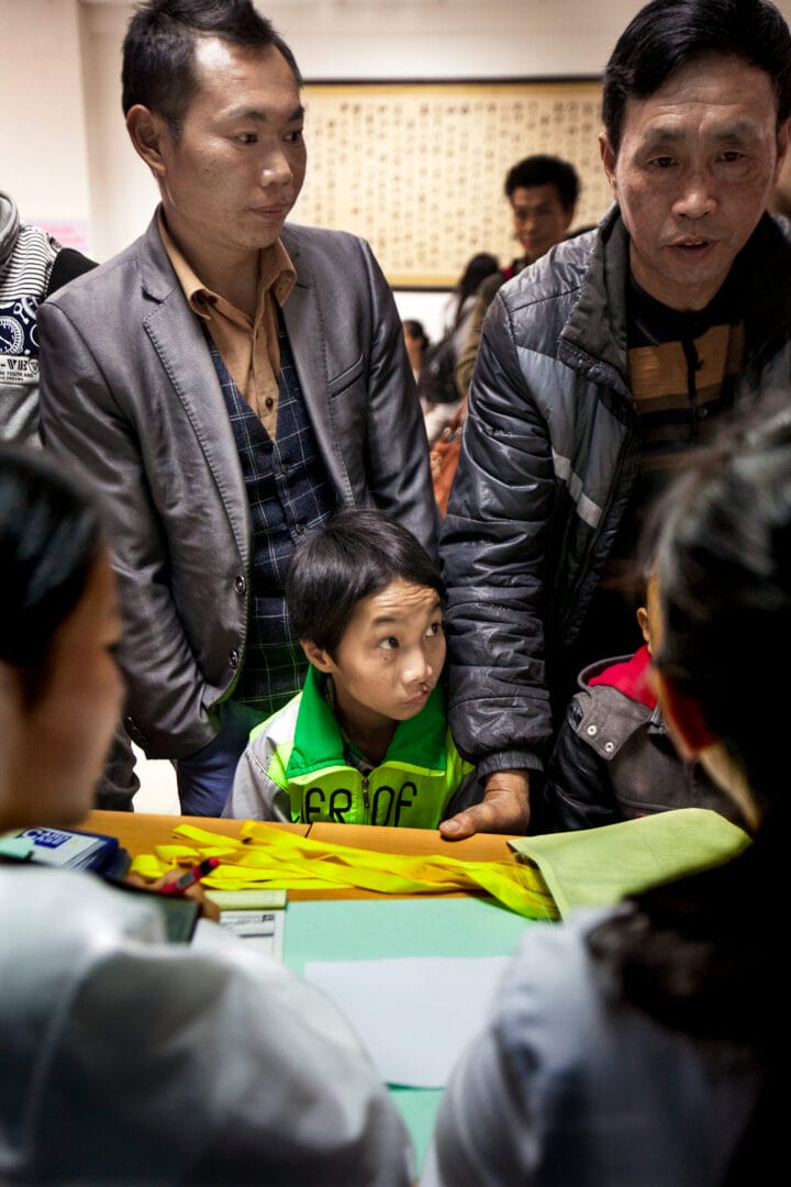 Paidong, left, registers Shijun for screening during a 2016 Operation Smile China surgical mission in Dafang. Photo: Zute Lightfoot.