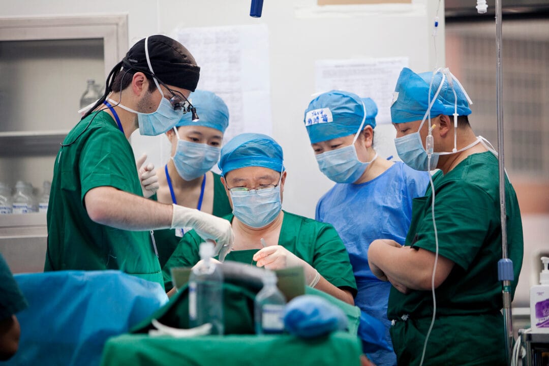 Volunteer plastic surgeon Dr. Shu Maoguo centre, and plastic surgeon observer Dr. Brad Gandolfi, left, perform surgery on 13-year-old Shijun. Photo: Zute Lightfoot