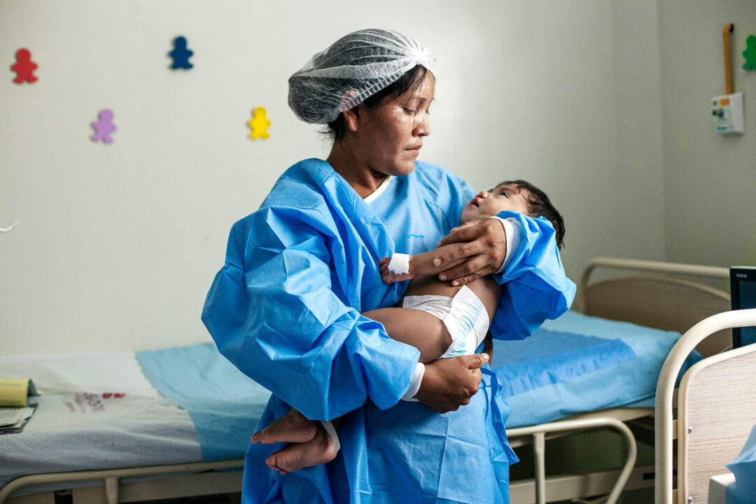 Mum holds daughter after cleft surgery