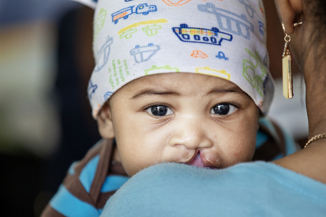 4 months old Jose Luis peers over a shoulder. Photo by Marc Ascher.