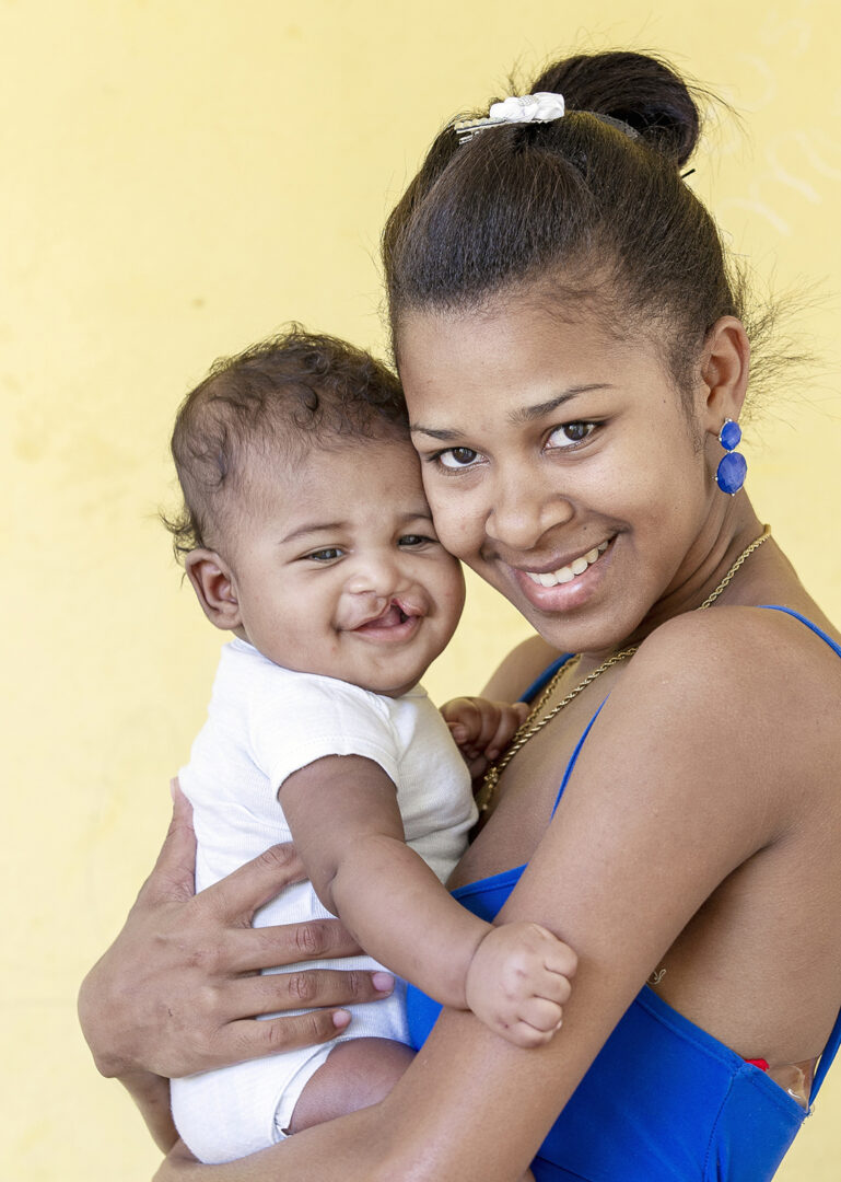 Mum Yaniris smiles and cuddles Jose Luis. Photo by Marc Ascher.