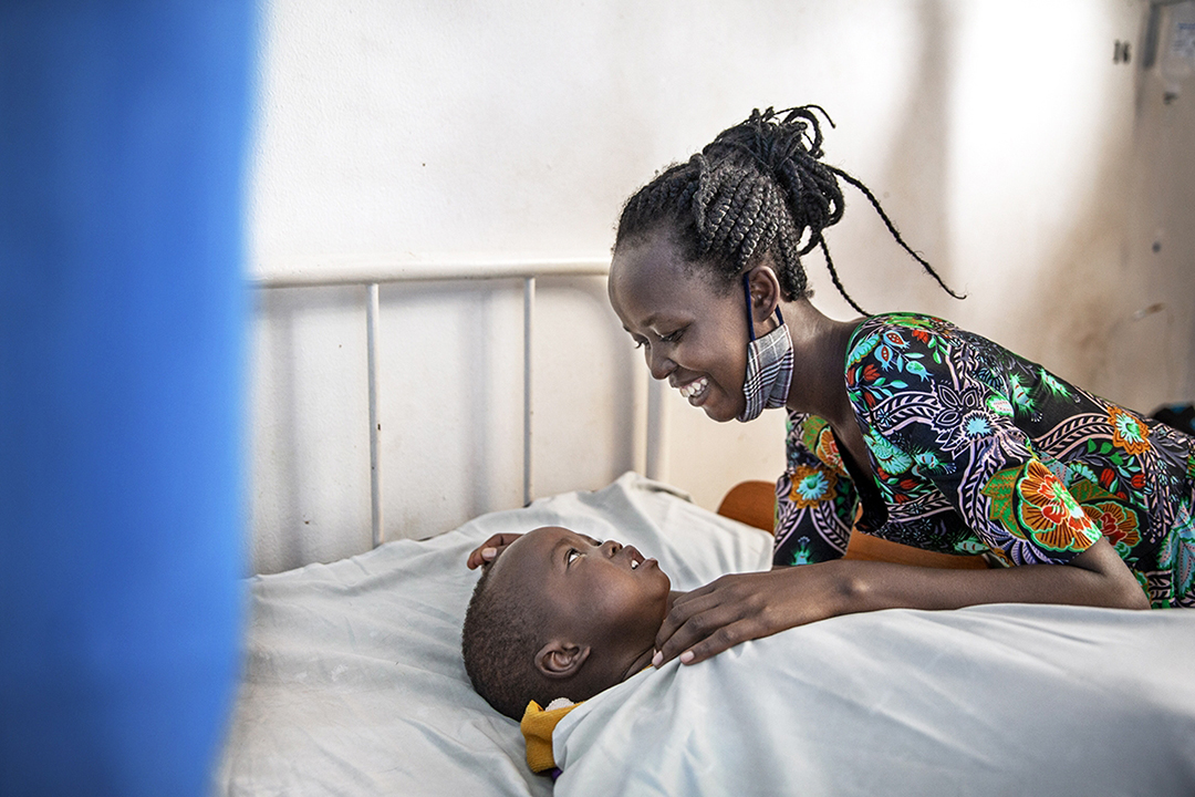 Mum Fidelite smiles at son Joshua as he rests in bed. Photo by Jorgen Hildebrandt.