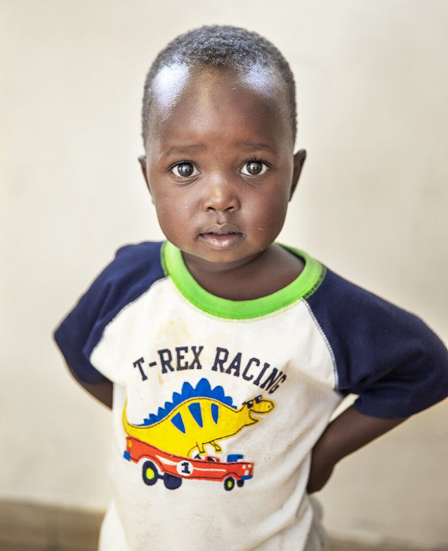 Two year old Joshua staring whilst wearing a t shirt with a T-Rex on the front. Photo by Jorgen Hildebrandt.
