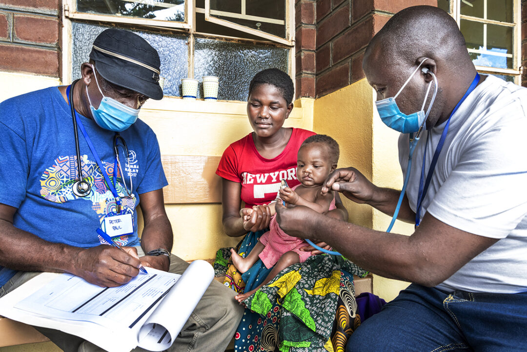 Little James and his mother, going through medical evaluation with anaesthesia officers Peter and Godfrey. Photo: Margherita Mirabella