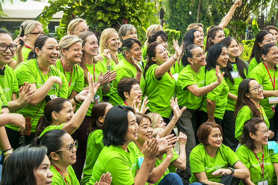 Members of the team wearing bright green tshirts, smiling and waving in Cebu City, Philippines. Photo: Rohanna Mertens.