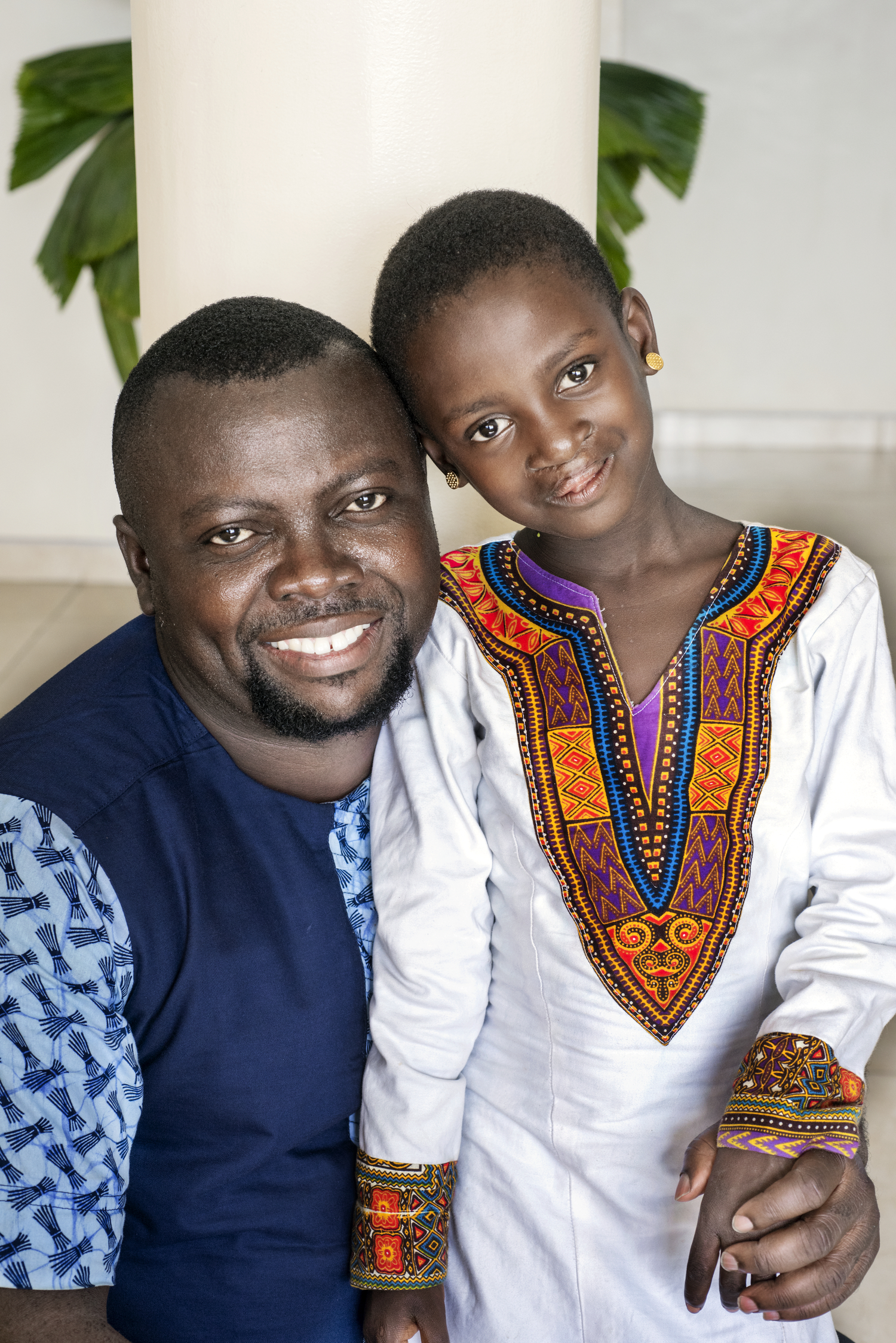 Patient Coordinator Clement Ofosuhemeng with Afia, a little patient who received care by Operation Smile.